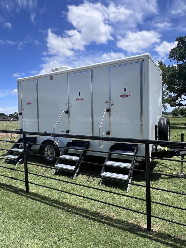 Luxury restroom trailer parked at a North Texas ranch property under open sky