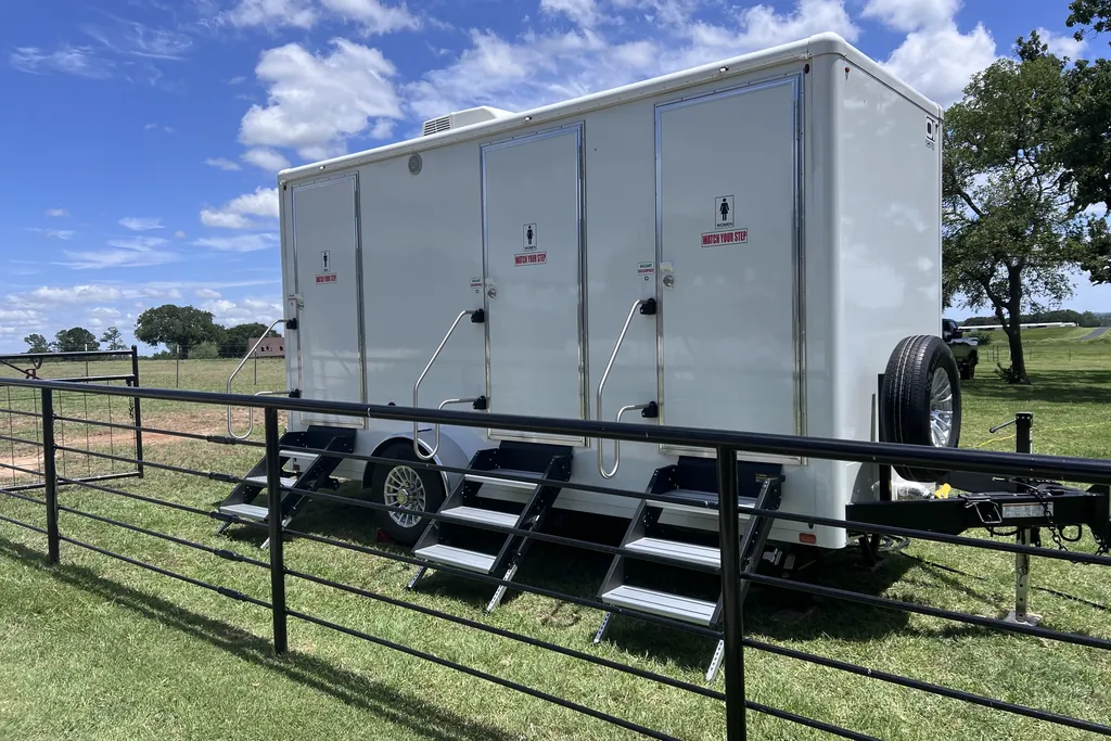 Luxury restroom trailer staged for an outdoor event on open Texas pasture