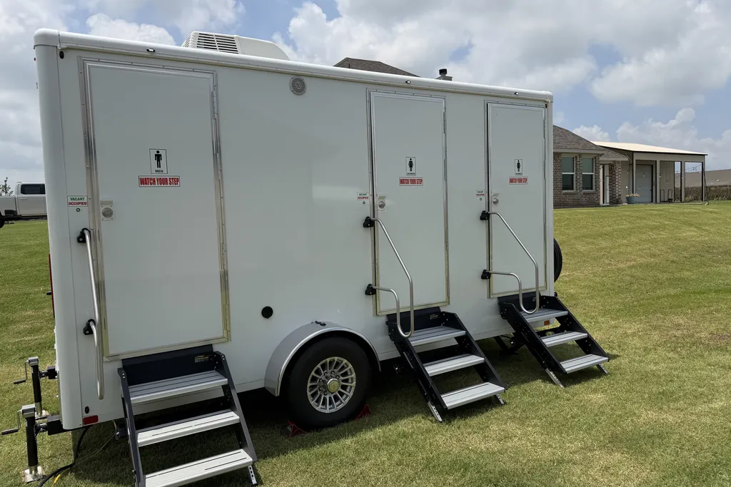 Three-station luxury restroom trailer set up on a residential lawn in North Texas
