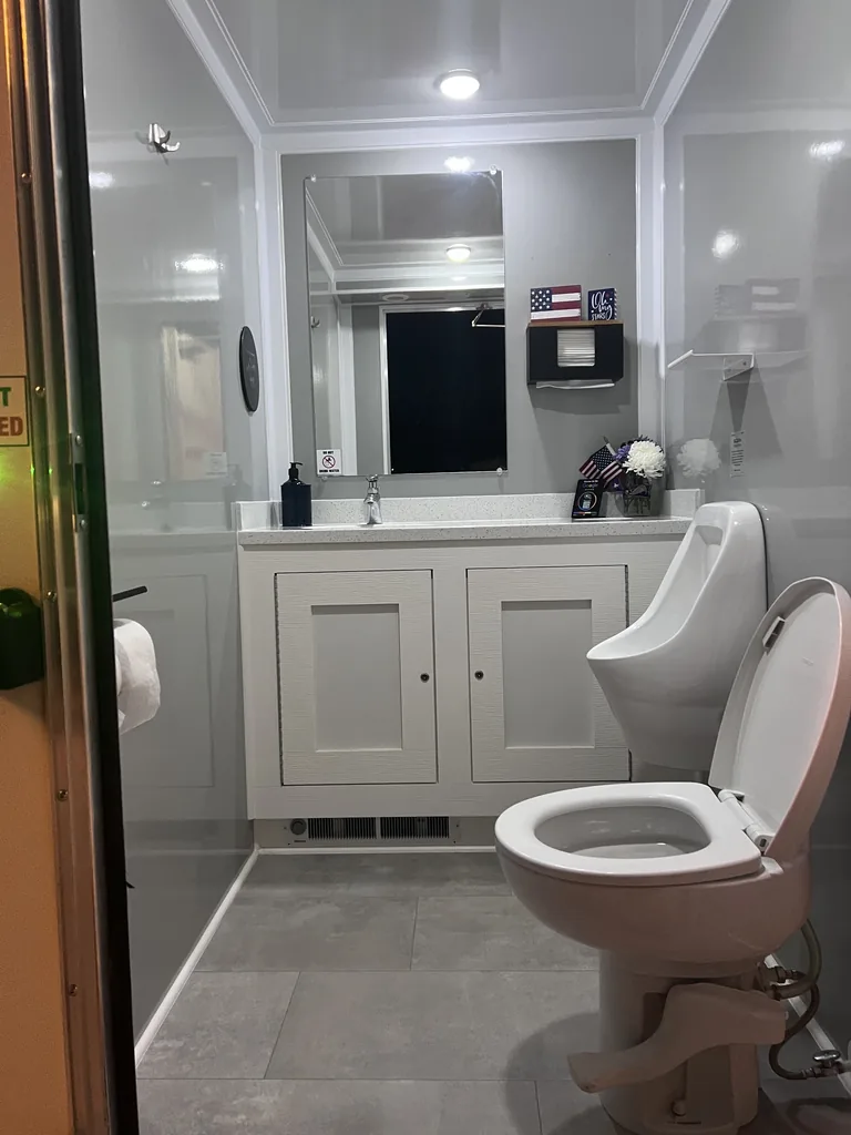 Men's restroom suite interior with vanity, urinal and porcelain toilet