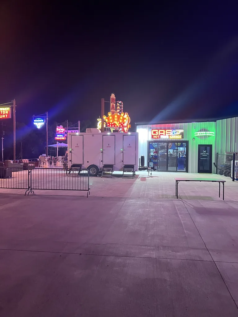 Luxury restroom trailer lit up at an evening event venue in North Texas